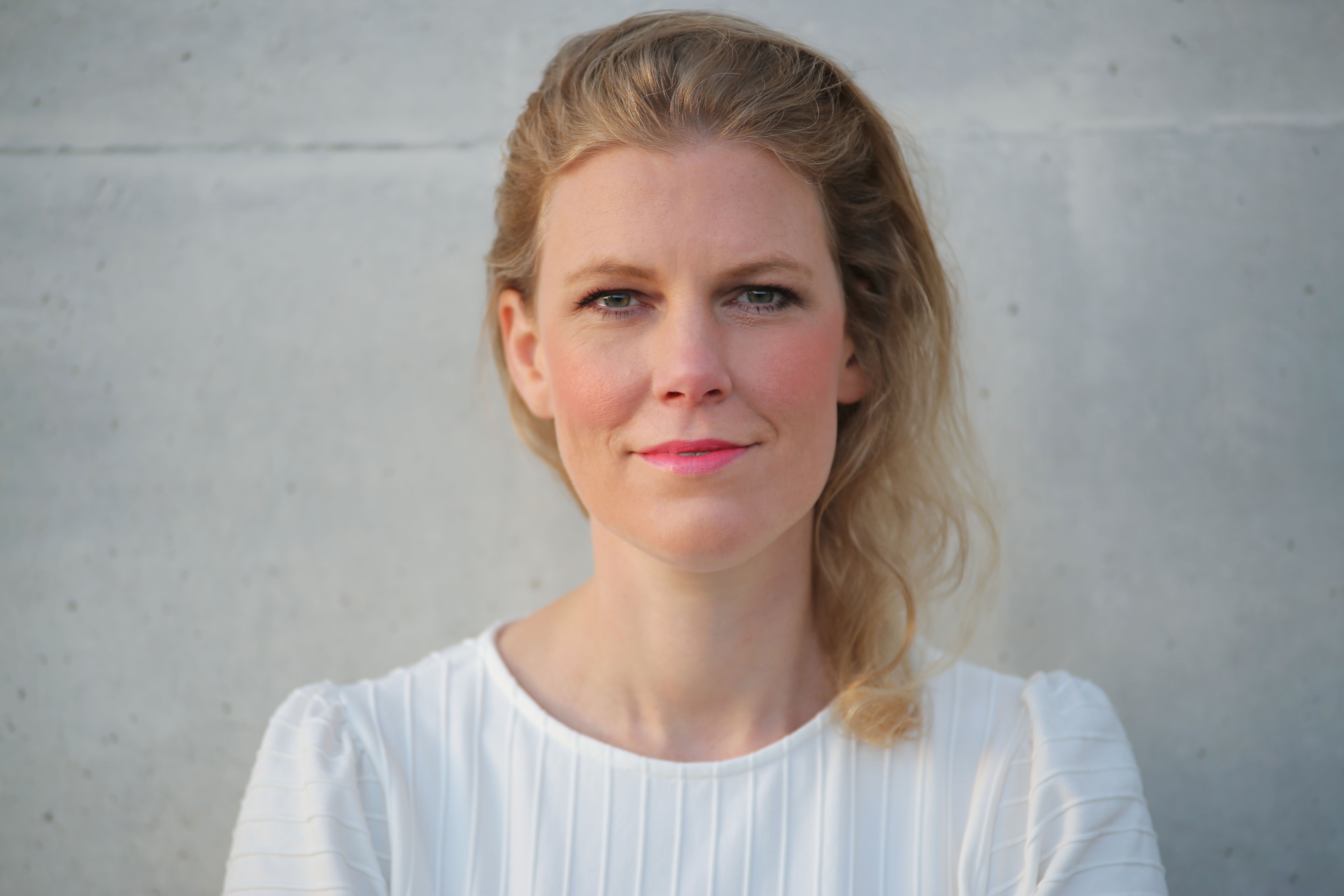 Mittelalte, blonde, langhaarige Frau, lächelnd.